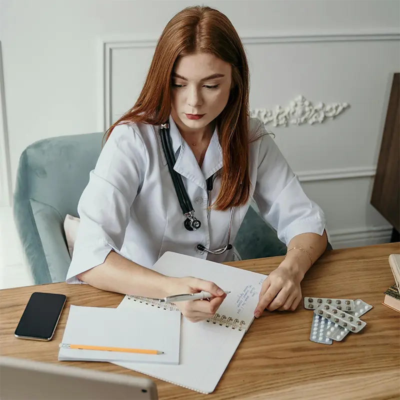 Médecin du travail consultant un dossier médical sur ordinateur lors d'une visite de mi-carrière avec un patient